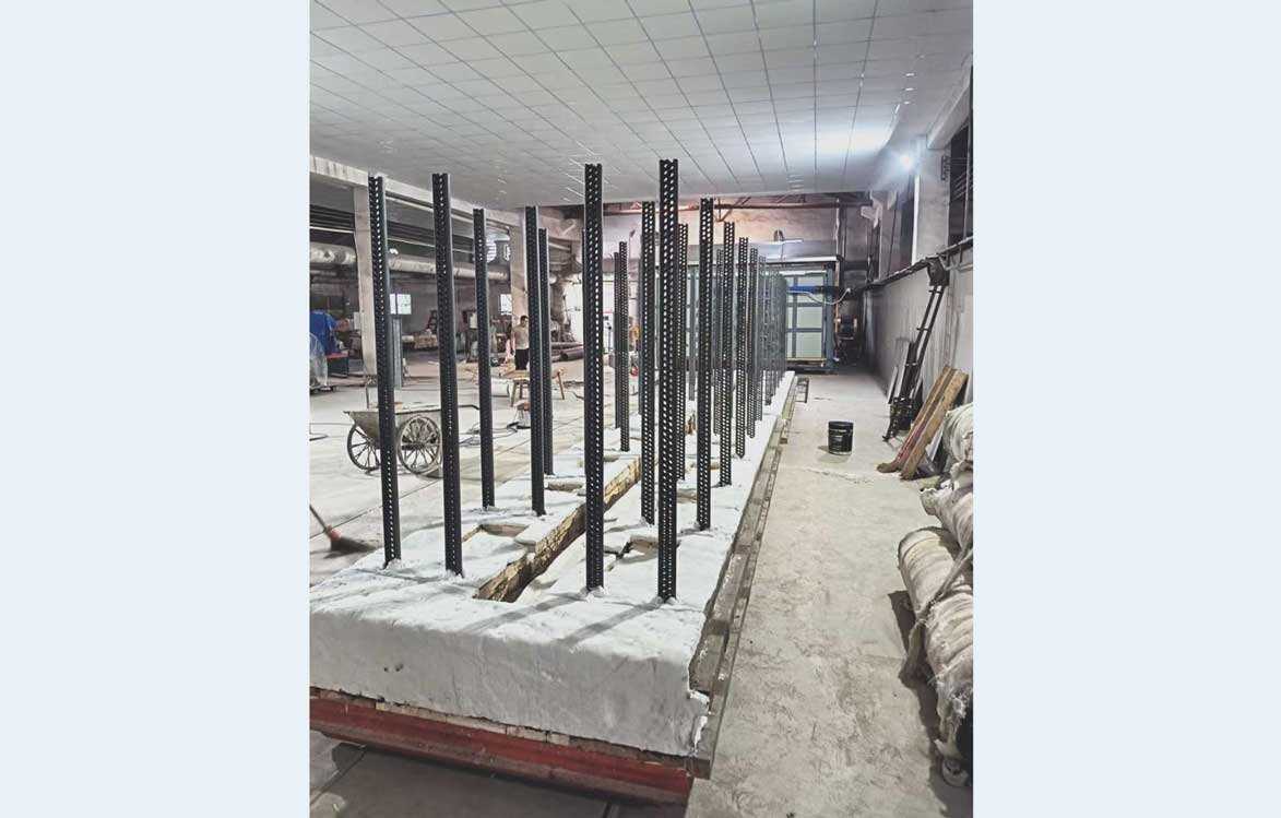 Kiln posts installed and aligned on kiln car base for post-and-shelf kiln furniture system