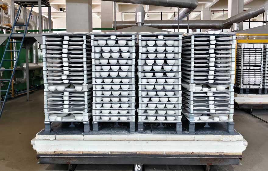 Shuttle kiln car loaded with porcelain ware using silicon carbide kiln shelves and mullite supports