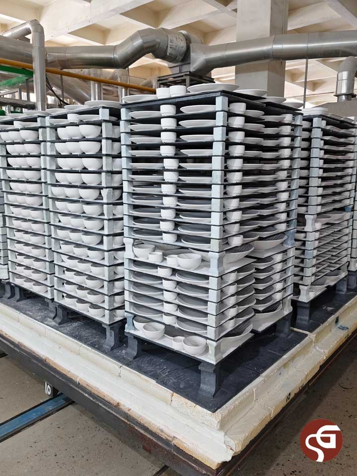 Kiln furniture system: Reaction-bonded silicon carbide (RBSiC) shelves and mullite blocks loaded with ceramic bowls and plates for firing